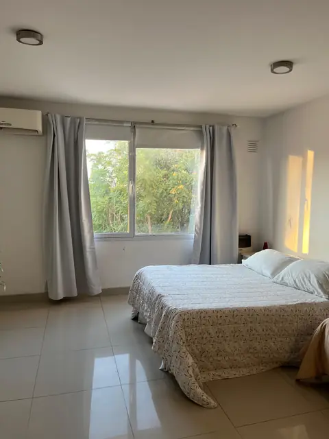 Dormitorio con cama matrimonial y ventanal